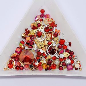 treasure pot of mixed nail decoration in a red theme with gems and gold and silver metal decoration and caviar beads